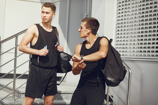 Handsome men in a sports clothes standing in a city - Fotoğraf, Görsel