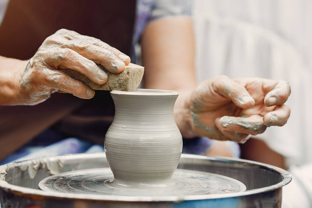 Grandmother with a grandchildren make pitchers in pottery - 写真・画像
