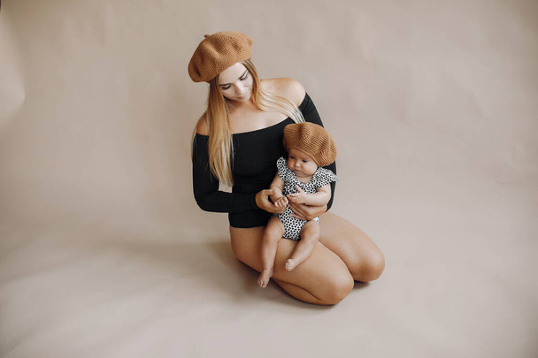 Elegant mother with cute little daughter in a studio - Фото, зображення