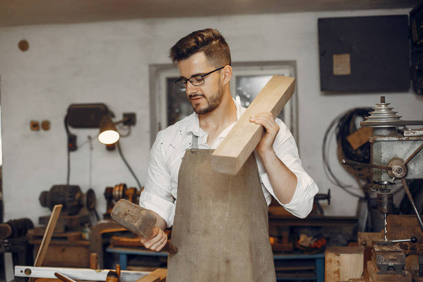 Handsome carpenter working with a wood - Valokuva, kuva