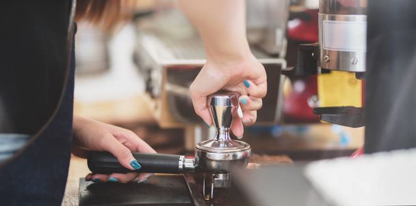 Tiro cortado de profissional barista feminino moagem de grãos de café torrados frescos no café
  - Foto, Imagem