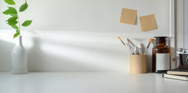 Minimal workspace with copy space and ceramic vase decorations and office supplies  - Photo, Image