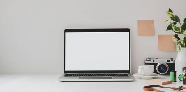 Маскировка ноутбука в минимальном рабочем месте с копировальным пространством и офисными принадлежностями на белом столе и белом фоне стены
  - Фото, изображение