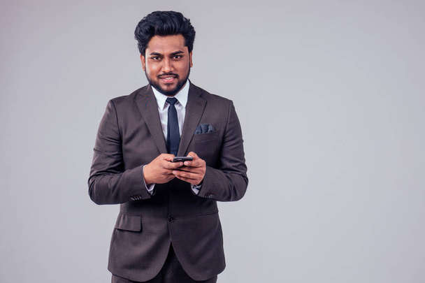 Erfolg gutaussehender arabischer Geschäftsmann klassischer Anzug im Telefongespräch vor weißem Studiohintergrund - Foto, Bild
