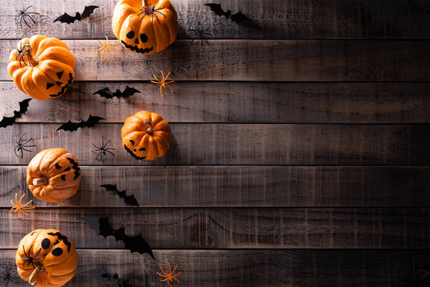 Вид сверху на хеллоуинские крабы, оранжевого медведя, белого призрака, летучую мышь и паука на темном деревянном фоне с пространством для копирования текста. Хэллоуин
. - Фото, изображение
