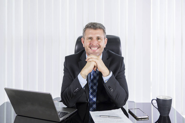 Kaukasische zakenman glimlachend naar camera op kantoor - Foto, afbeelding