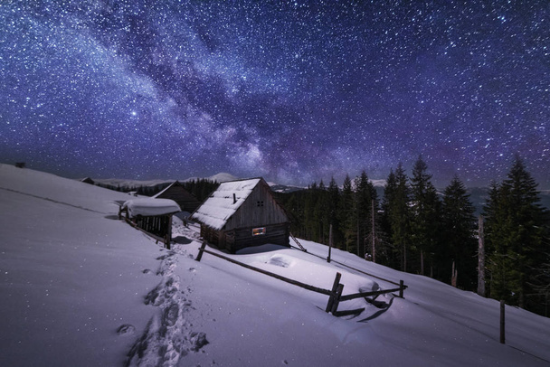 Paesaggi fiabeschi dell'inverno Montagne Carpazie con una suggestiva via lattea nel cielo tende turistiche e case innevate nelle valli
 - Foto, immagini