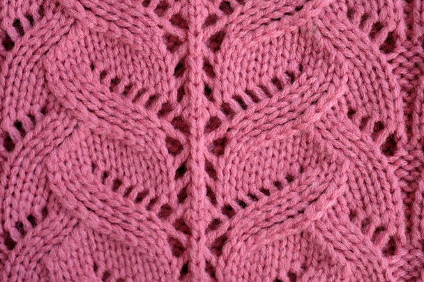 ハンドメイドの繊細なピンクの透かし彫り編み。ピンクのニットセーター。ピンクの粗いニットの質感. - 写真・画像