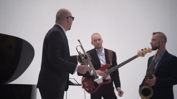 Bajo guitarrista y trompetista en una banda
 - Metraje, vídeo