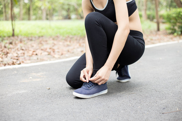 молодая бегунья завязывающая шнурки, спортивная концепция
 - Фото, изображение