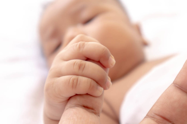 Newborn baby holding father's finger While sleeping comfortably - Φωτογραφία, εικόνα