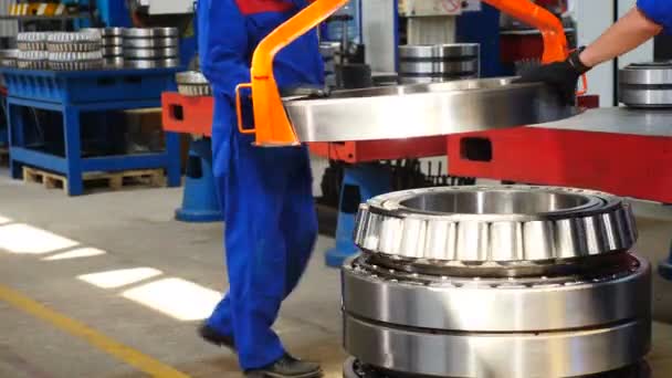 Massive bearing assembly. Close up. Worker lifts part of rolling bearing with hoister. Heavy machinery concept. Part of manufacture. Shot in 4k - Footage, Video