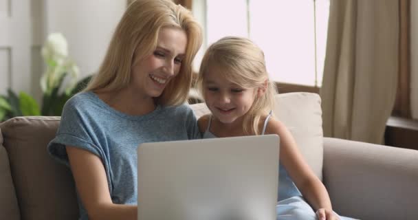 Happy mum and cute kid daughter having fun using laptop - Imágenes, Vídeo