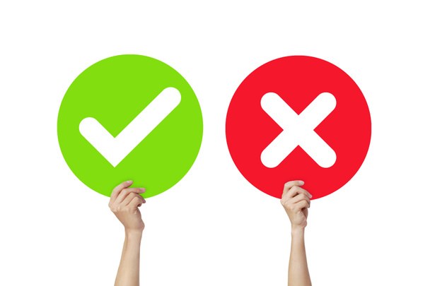 Manos sosteniendo letrero marca de verificación verde y marca X roja o letreros verdaderos y falsos aislados sobre fondo blanco
. - Foto, Imagen