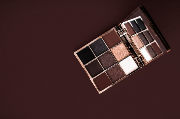 Палитра теней для век и кисть для макияжа на шоколадном фоне, глаза
 - Фото, изображение