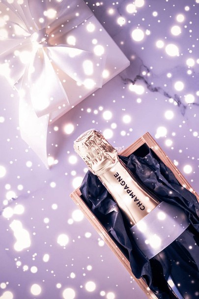 Botella de champán y caja de regalo en brillo de vacaciones púrpura, New Yea
 - Foto, Imagen