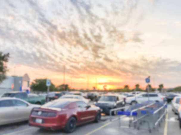 Garaje de estacionamiento borroso con carros de regreso bajo la nube del atardecer cerca de Dallas
 - Foto, imagen