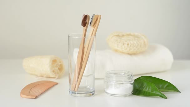Ženská ruka bere bambusový dřevěný kartáček ze skla v koupelně. Koncepce nulového odpadu a hygieny - Záběry, video