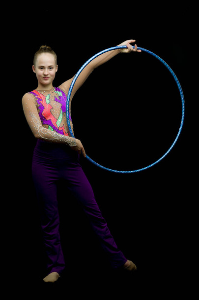 A girl gymnast performs an exercise with a hoop. - Fotó, kép