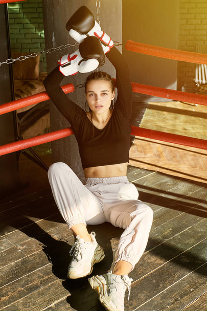 girl in boxing gloves sits in the ring - Фото, зображення
