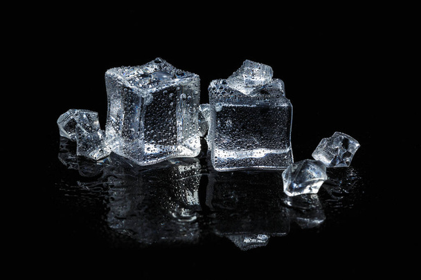 cubitos de hielo sobre fondo de vidrio aislado negro
 - Foto, Imagen