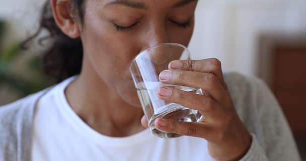 durstige dehydrierte Afrikanerin hält Glas Trinkwasser in der Hand, Nahaufnahme - Filmmaterial, Video