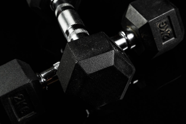 sport súlyzók fekete gumi nyéllel fekete elszigetelt háton - Fotó, kép