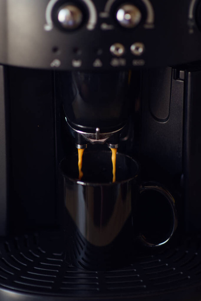 delicious cup of espresso being poured from a domestic espresso machine - 写真・画像