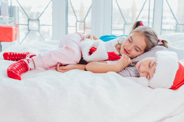 Two exhausted kids are sleeping, cuddling sweetly after new year party. - Photo, Image
