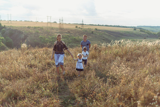 Οικογένεια που τρέχει μέσα από το πάρκο στην πτώση ή το φθινόπωρο - Φωτογραφία, εικόνα