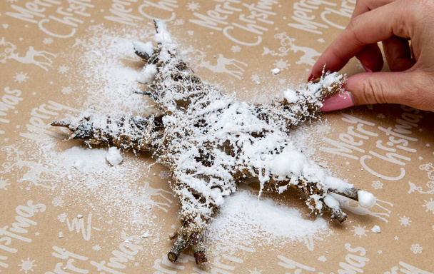 rocía nieve artificial sobre un juguete navideño improvisado
 - Foto, imagen