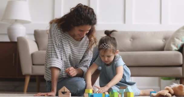 Cute small kid girl and mom laugh play wooden blocks - Felvétel, videó