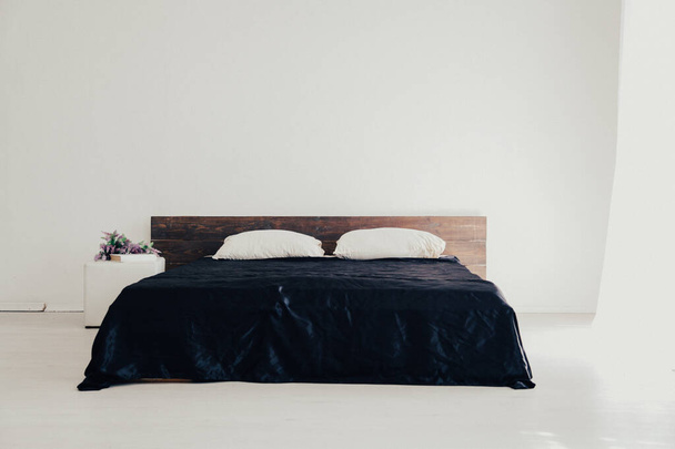 Interior dormitorio blanco y cama con sábanas negras
 - Foto, Imagen