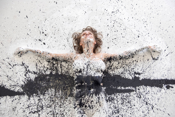 Retrato e braços de mulher pintada artisticamente abstrata em tinta preta e branca no chão em estúdio. Arte de pintura corporal expressiva criativa
. - Foto, Imagem
