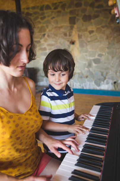 Children's and women's hands on the piano keys. - Foto, imagen