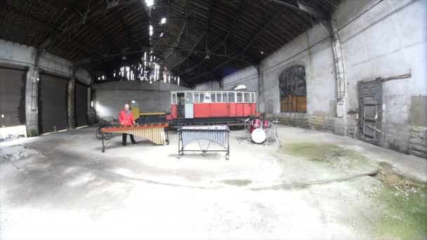 Muž Hudebník hraje marimba ve staré továrně na opravy vlaků - Záběry, video