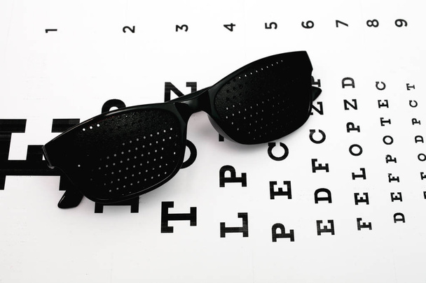 Las gafas de entrenamiento perforadas están sobre la mesa para el examen ocular
 - Foto, imagen