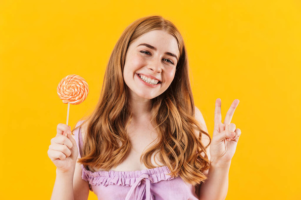Happy young cute teenage girl holding sweet candy lollipop. - Photo, Image