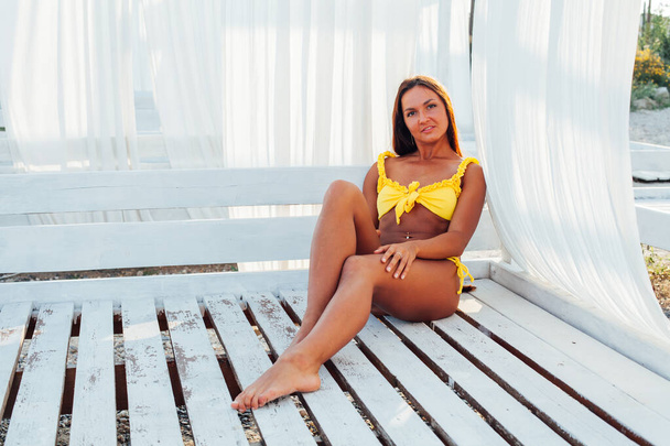femme mince en maillot de bain jaune bains de soleil sur la plage au bord de la mer
 - Photo, image