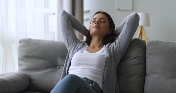 Relaxed calm beautiful girl leaning on sofa dreaming enjoying wellbeing - Filmmaterial, Video