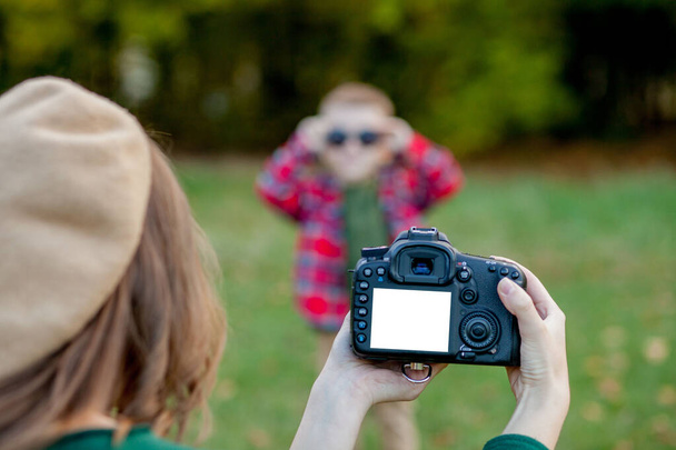 Woman photographer photographing the child to spend outside in t - Foto, Bild