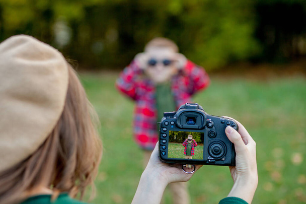 Woman photographer photographing the child to spend outside in t - Foto, Bild
