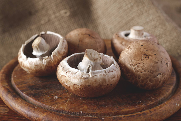 Свежие коричневые грибы на деревянном столе
 - Фото, изображение