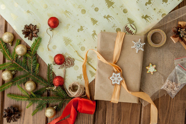 Christmas gift box, decor and fir tree branch on wooden table. T - 写真・画像