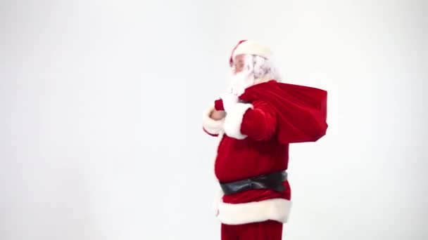 Christmas. Santa Claus on a white background takes out a red box with a bow from a bag, gives it. Present. Surprise. - Filmati, video