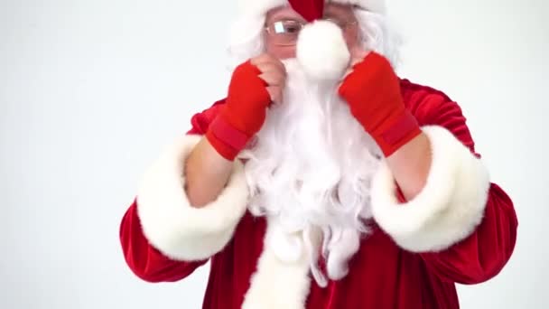 Christmas. Santa Claus on a white background in red bows for boxing and kickboxing fulfills blows. The image of a fighter. Humor, funny, fun, joke, has its own bumbon. - Video
