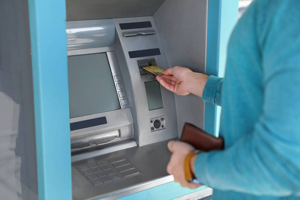 Young man using modern cash machine outdoors, closeup - Photo, image