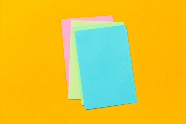 stack of colored stickers on a vivid yellow background - Foto, Bild