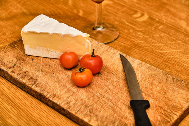 Blue cheese and knife on cutting board and red wine - Photo, image