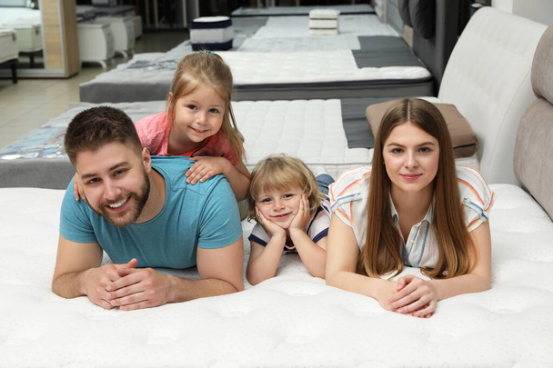 Happy family lying on new orthopedic mattress in store - Photo, Image